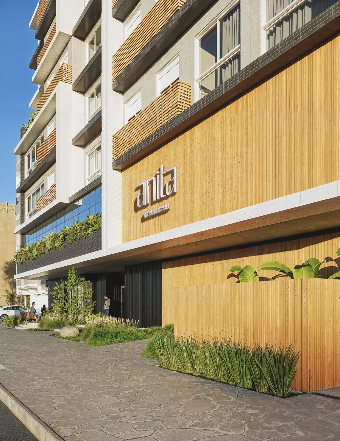 Entrada do Residencial Anita com letreiro e hall decorado no térreo em Capão da Canoa