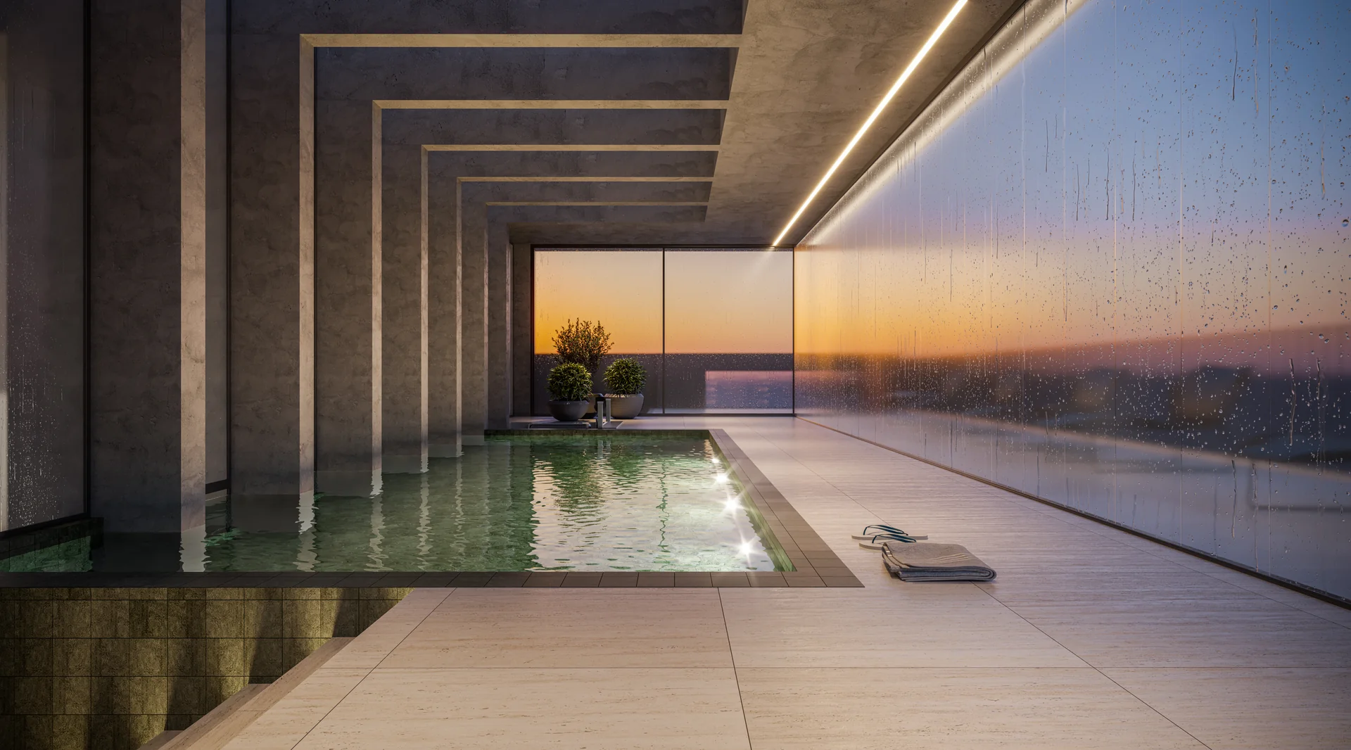 Piscina térmica coberta do Barcelona Smart Living ao entardecer, com pilares de concreto e vista para o mar