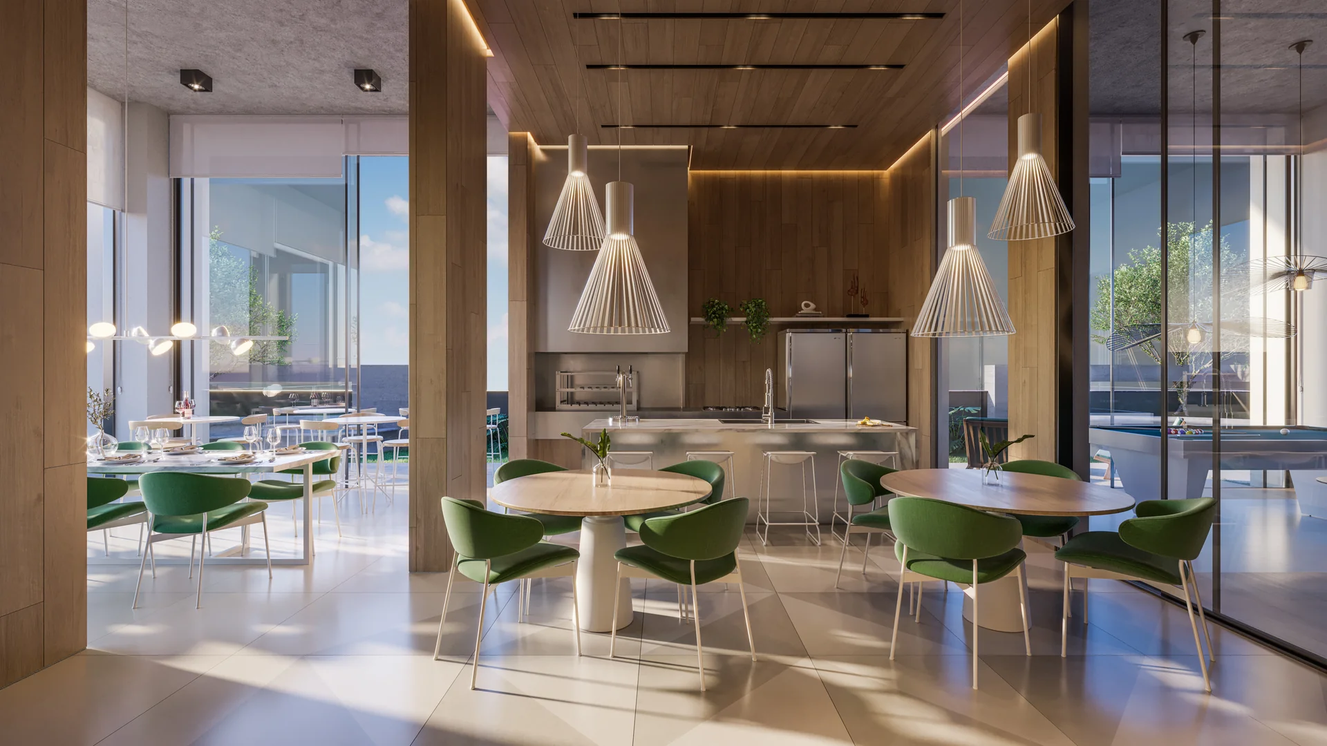 Salão de festas gourmet do Barcelona Smart Living com mesas, cadeiras verdes e cozinha integrada