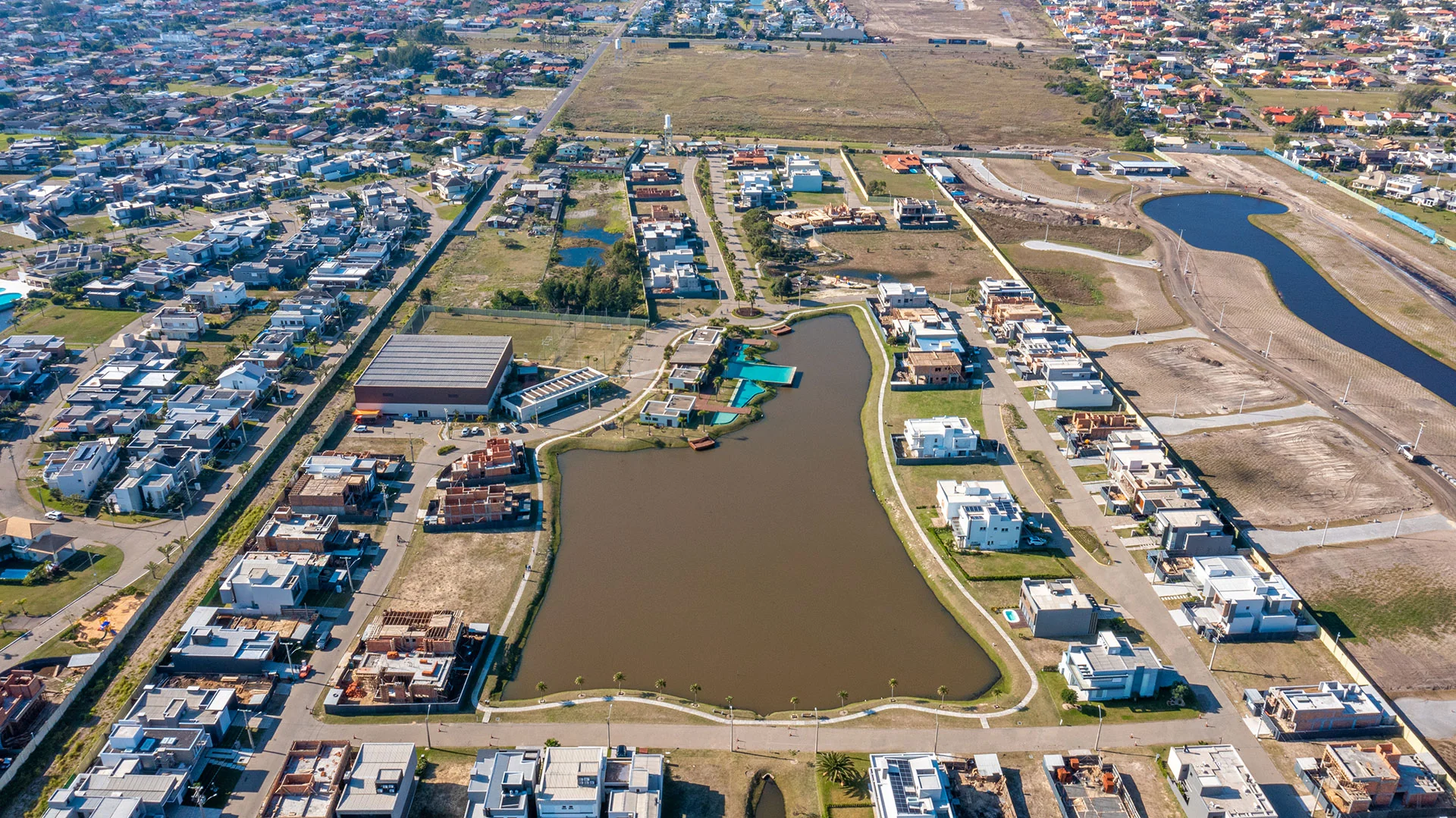 Foto aérea do Blue Xangri-lá mostrando o lago central, o clube e os lotes ao redor