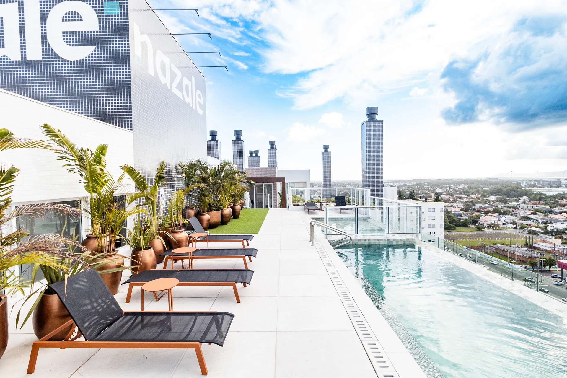 Piscina de borda infinita no rooftop do Del Paine, com espreguiçadeiras e vista panorâmica de Capão da Canoa