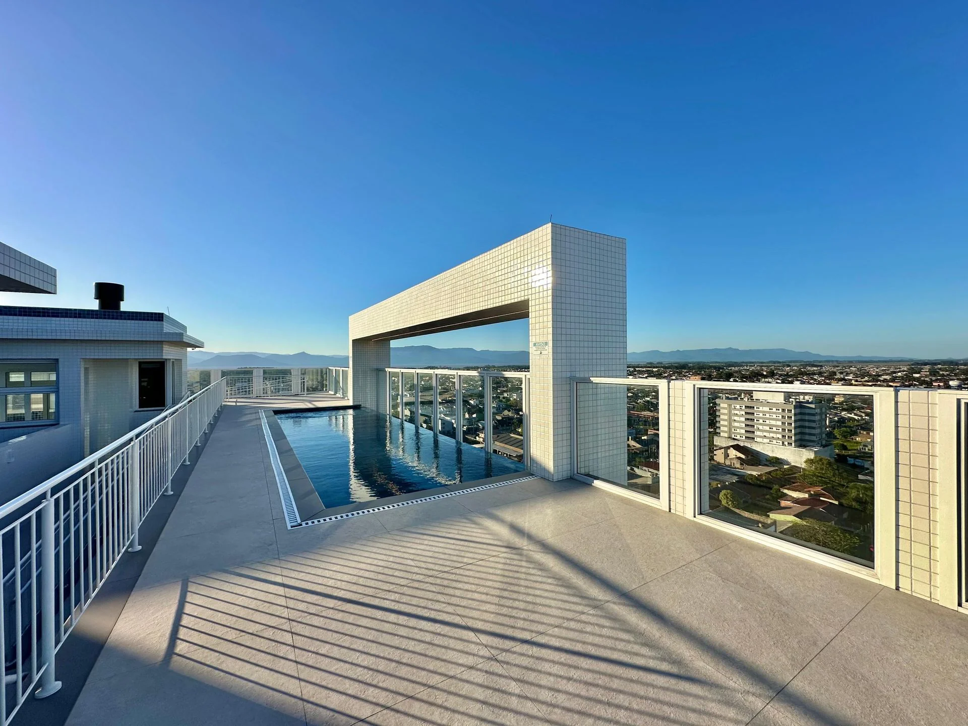 Piscina de borda infinita no rooftop do Domênico Home & Club, com vista panorâmica de Capão da Canoa