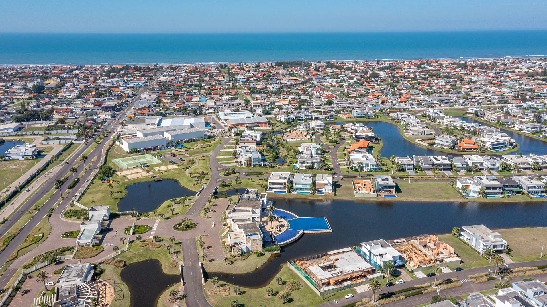 Foto aérea do Enseada Lagos de Xangri-Lá com as casas e lagos do condomínio e o mar ao fundo