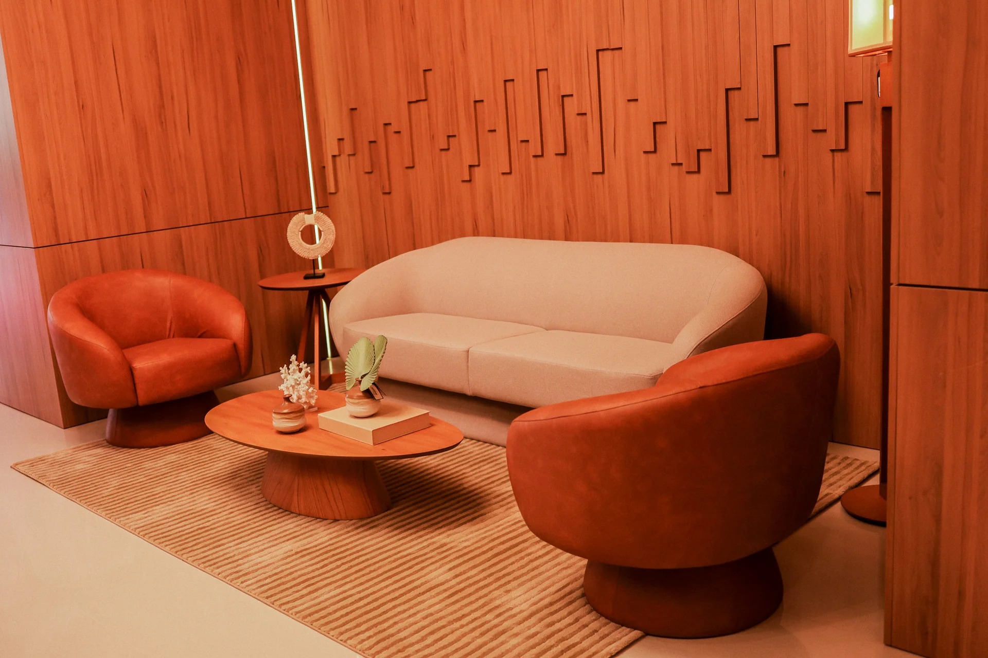 Foto real do lounge de entrada do Epic Residence com poltronas e painel de madeira ripada