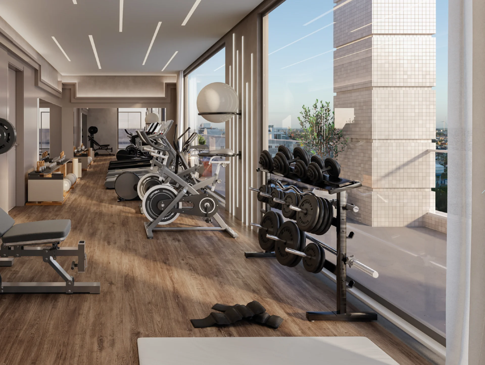 Academia do Four Seasons Residence com pesos livres, bikes e esteiras diante do vidro com vista da cidade
