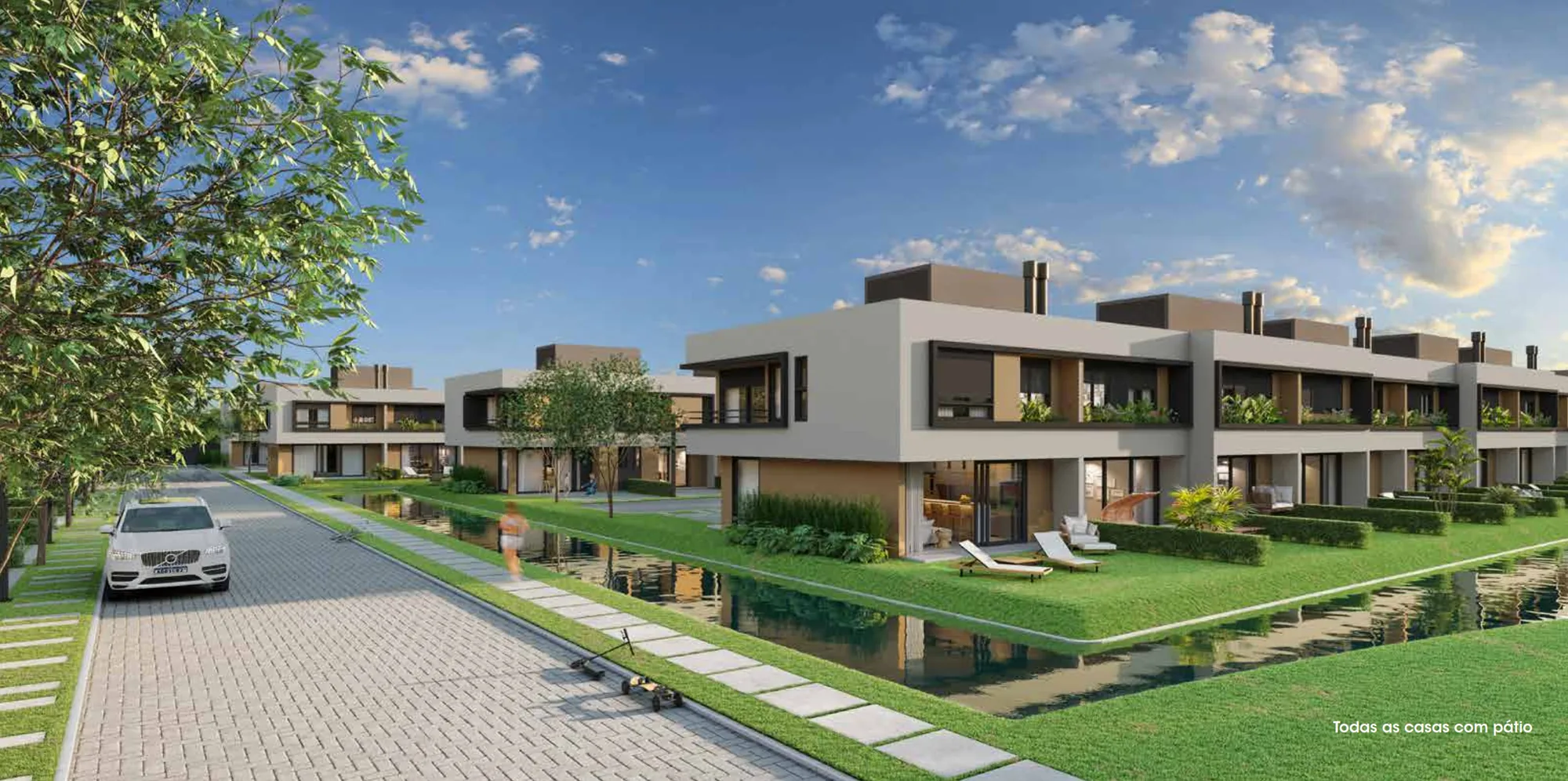 Rua interna do Gaia Atlântida Residences com casas contemporâneas e lago central