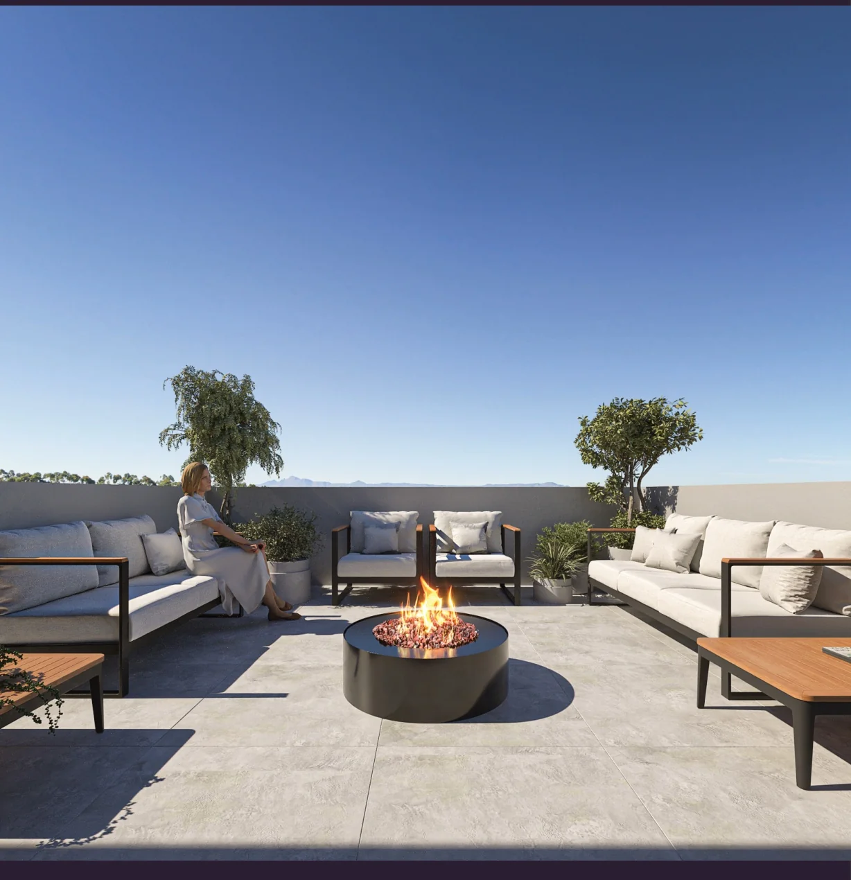 Lounge do rooftop do Gênesis com sofás e firepit aceso ao entardecer
