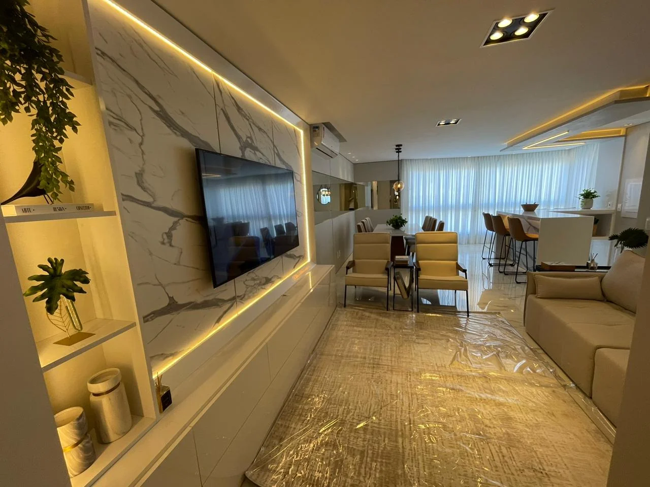 Sala de estar integrada de unidade decorada do Edifício João Alves Diniz, com vista para o litoral