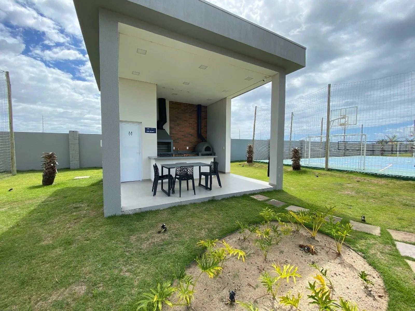 Quiosque gourmet do JOY ao lado das quadras, com churrasqueira e mesa