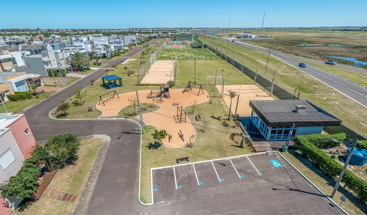 Playground externo do Las Palmas, com estruturas de madeira, próximo às quadras de areia