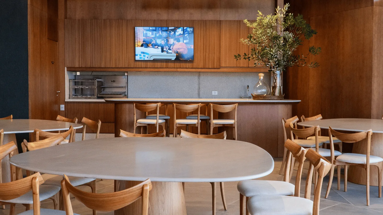Espaço gourmet interno do clube do Lótus Atlântida com lareira e vista para o lago