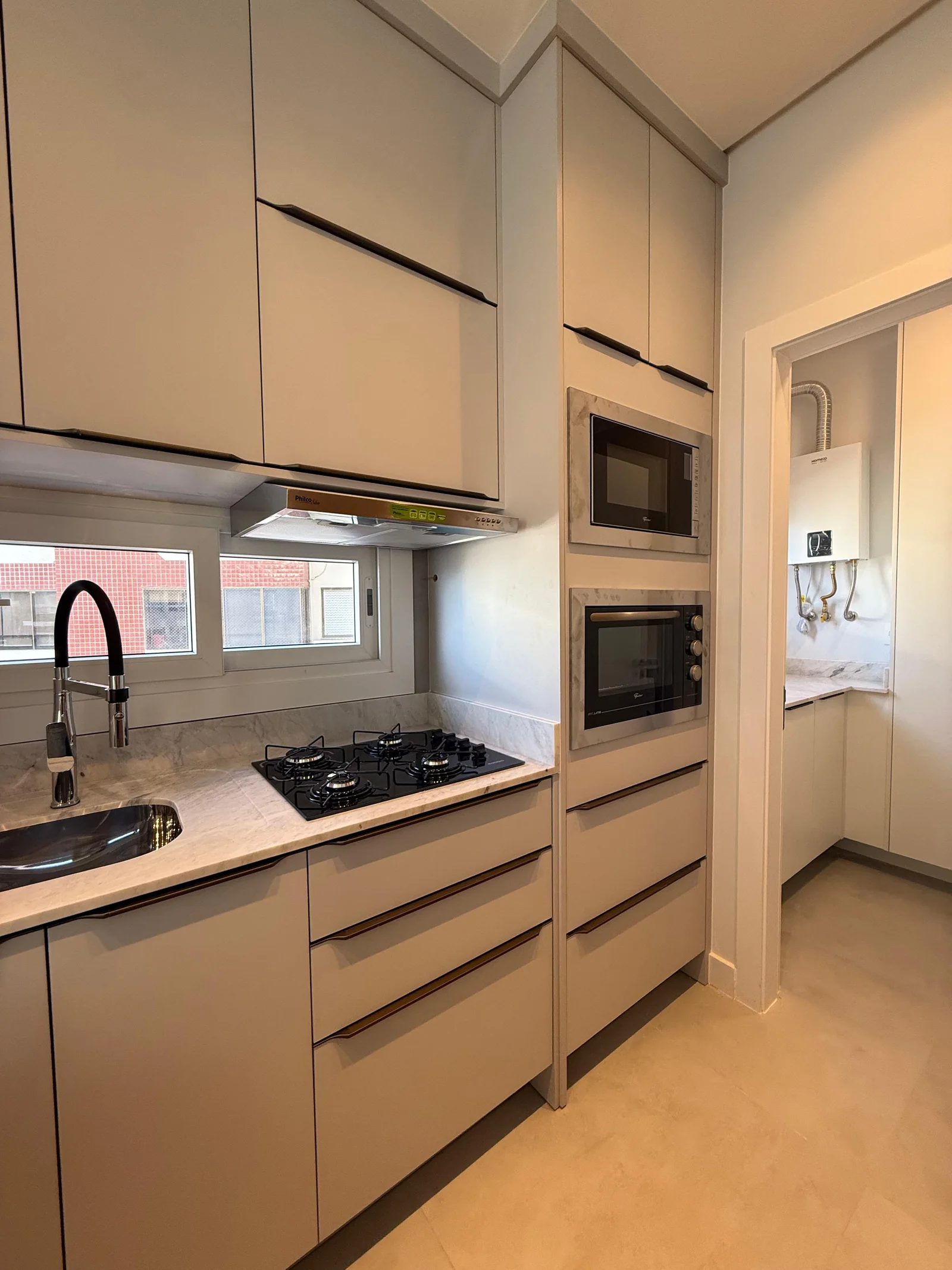 Cozinha do apartamento decorado do Santé Beach Home, com bancada em pedra e churrasqueira