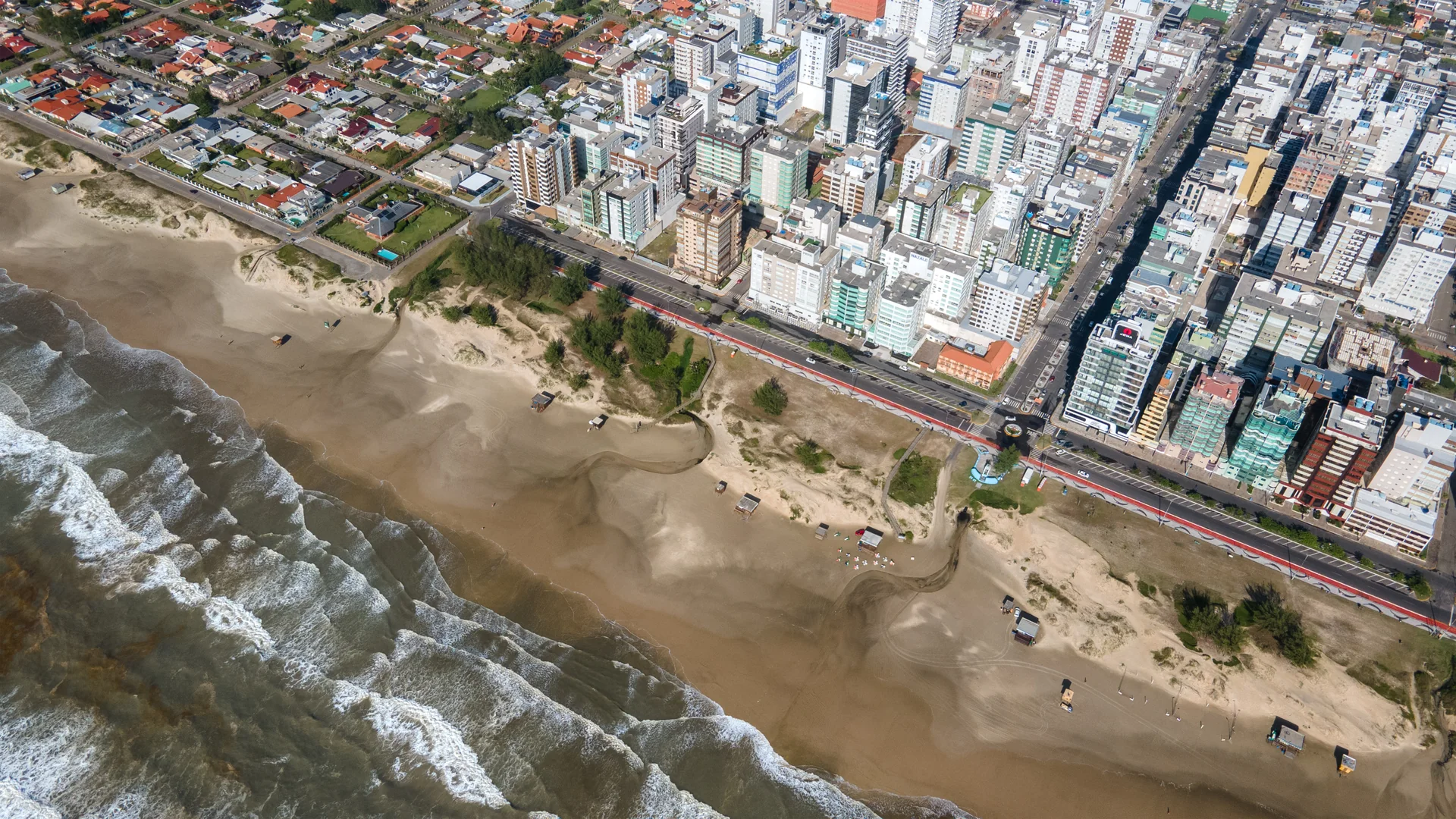 Vista aérea da orla de Capão da Canoa, com o calçadão, a faixa de areia e o tecido urbano do entorno do Vivaz Residence