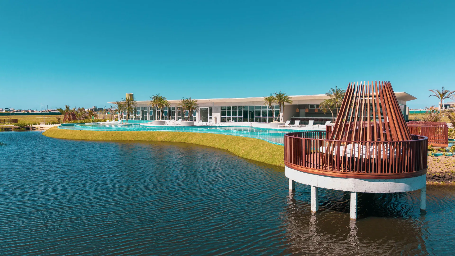 Club House do Wave Home Resort à beira do lago interno ao pôr do sol